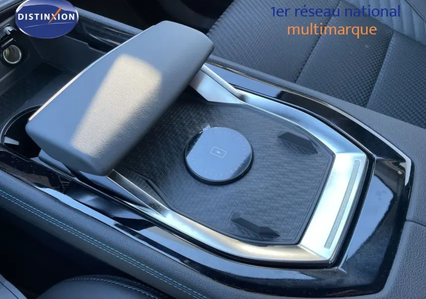 Vue rapprochée de la console centrale noire avec accoudoir et zone de recharge sans fil du Renault Austral 2026.