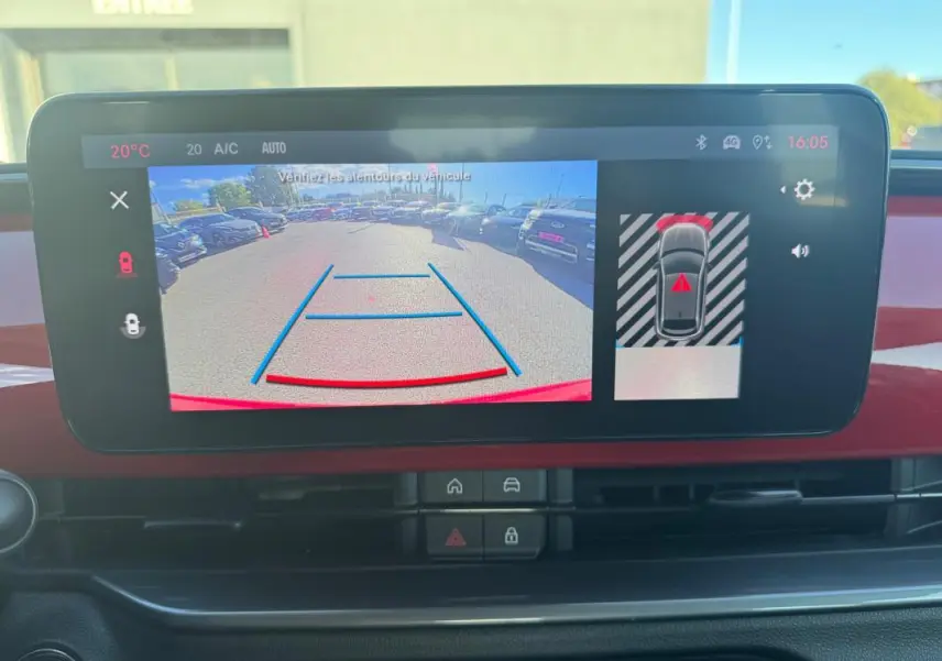 Écran central du tableau de bord du Fiat 600 T-Gen 3 rouge montrant la caméra de recul avec guidage de trajectoire.