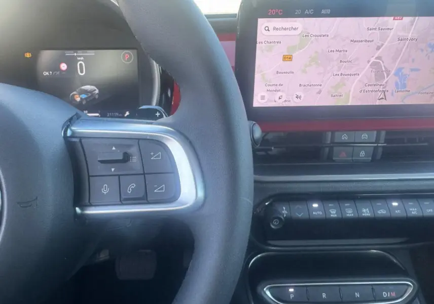 Vue intérieure centrée sur le volant et l’écran tactile du tableau de bord de la Fiat 600 rouge T-Gen 3 2025.