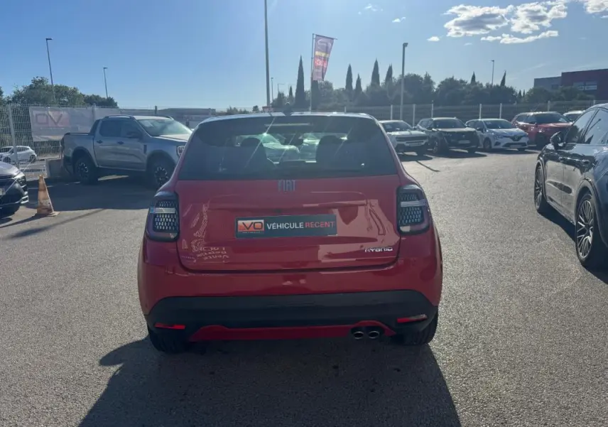 Vue arrière d'une FIAT 600 T-Gen 3 rouge 2025 avec double sortie d'échappement et feux arrière LED en parking extérieur.