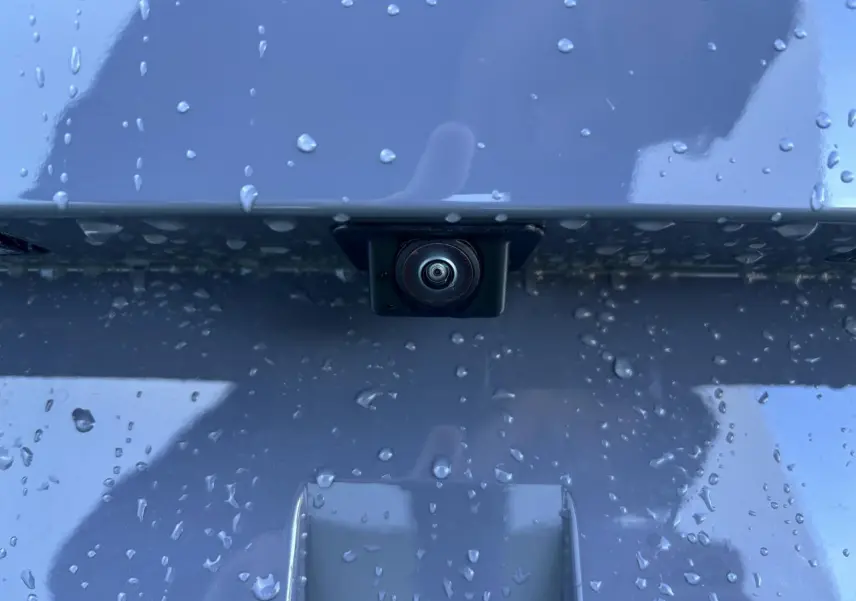 Gros plan sur la caméra de recul intégrée sur la malle arrière gris graphene d'une CUPRA Leon 2024.