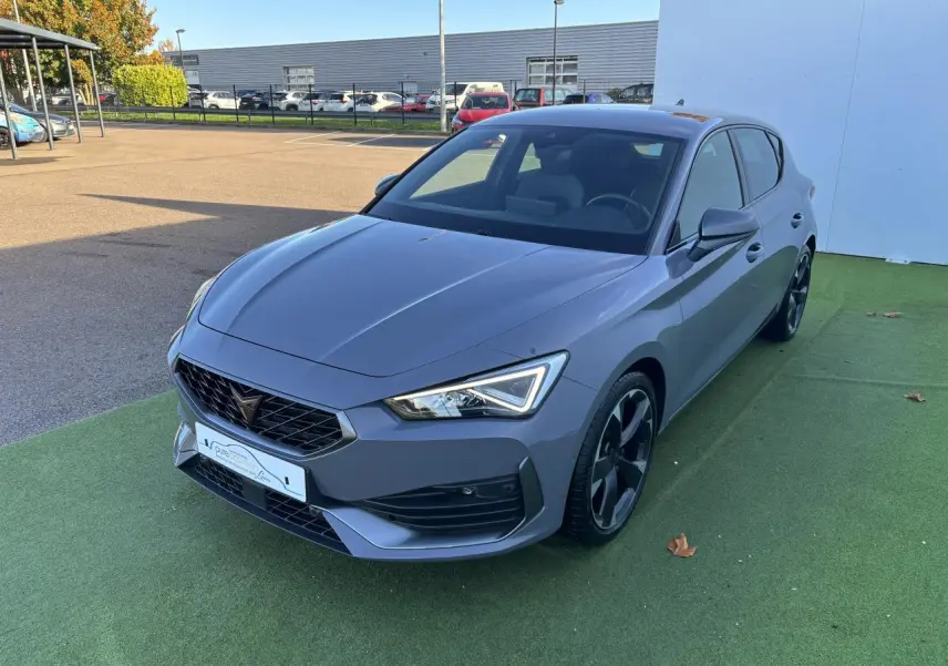 Vue 3/4 avant d'une CUPRA Leon 2024 gris Graphene avec jantes alliage noires et feux LED distinctifs.