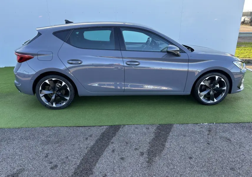 Profil droit d'une CUPRA Leon 2024 gris Graphene avec jantes alliage 18 pouces et vitres teintées arrière.