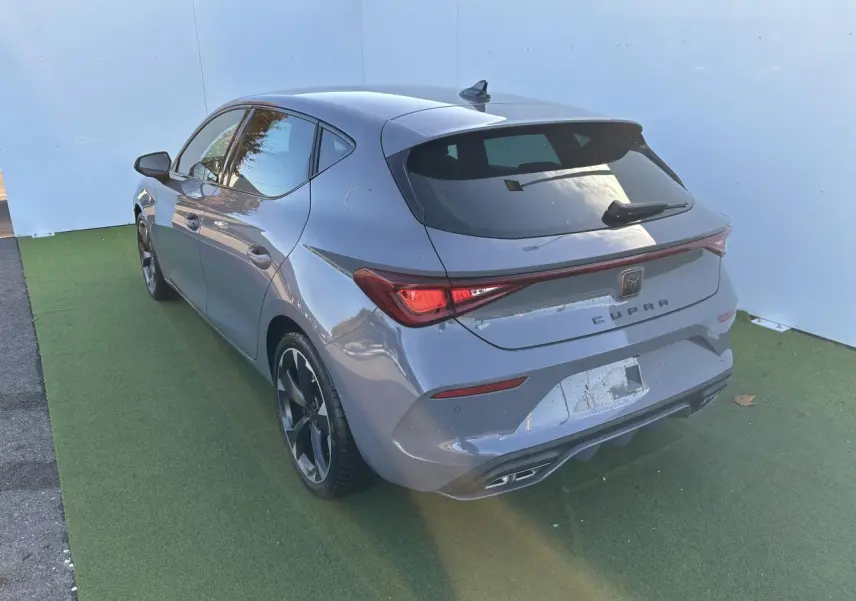Vue 3/4 arrière droite d'une CUPRA Leon 2024 gris Graphene avec feux LED et jantes alliage 18 pouces.