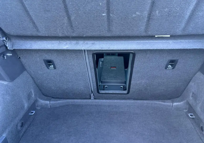 Vue intérieure du coffre du CUPRA Leon 2024 gris Graphene, montrant l'ouverture de la banquette arrière et les fixations Isofix.