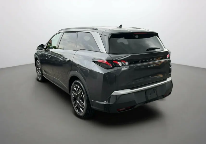 Vue 3/4 arrière gauche du Peugeot 5008 Hybrid gris titane avec toit noir et jantes alu 19 pouces.