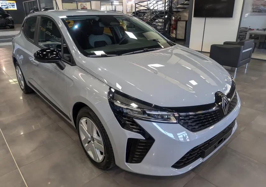 Renault Clio V Blue dCi 100 en gris Rafale, vue 3/4 avant gauche, avec calandre noire et jantes alliage.