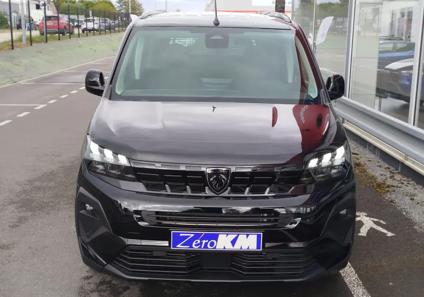 Vue avant d'un Peugeot Rifter 1.5 BlueHDi noir Perla Nera avec calandre noire et phares LED allumés.