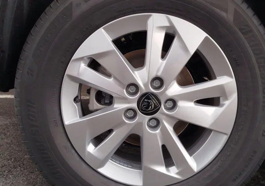 Gros plan sur la jante argentée du Peugeot Rifter 1.5 BlueHDi 130ch, avec logo lion au centre et pneu Bridgestone noir.