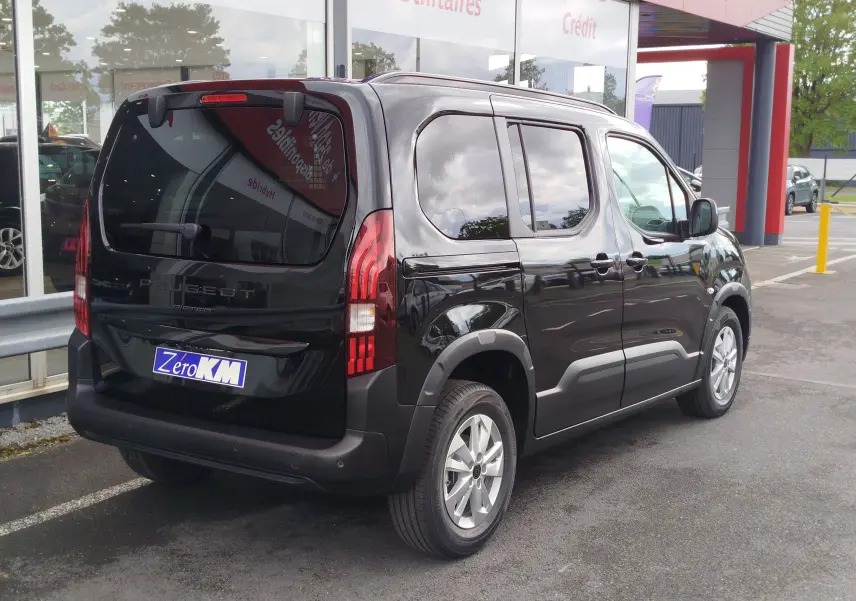 Peugeot Rifter noir Perla Nera vu en 3/4 arrière droit, avec vitres teintées et jantes alliage 16 pouces.