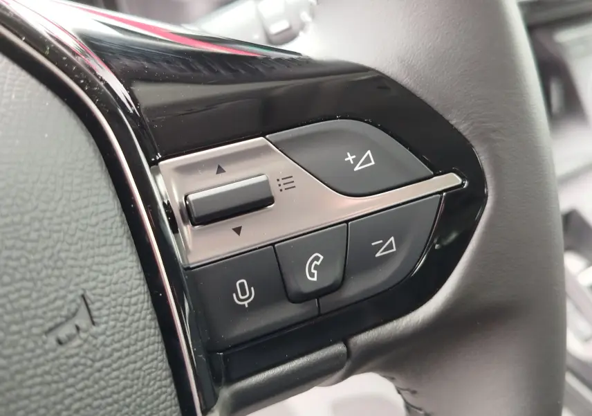 Gros plan sur les commandes au volant côté gauche du Peugeot Rifter noir Perla Nera, boutons de volume et appels.