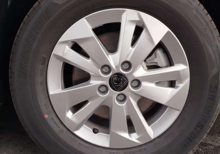 Gros plan sur la jante argentée du Peugeot Rifter 2026, mettant en valeur le logo central et le pneu Bridgestone noir.