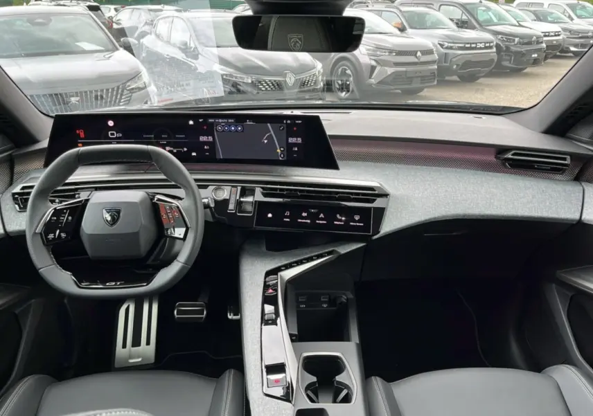 Vue intérieure avant du Peugeot 5008 Hybrid 145 GT 2025, tableau de bord moderne avec écran large et volant cuir multifonctions.