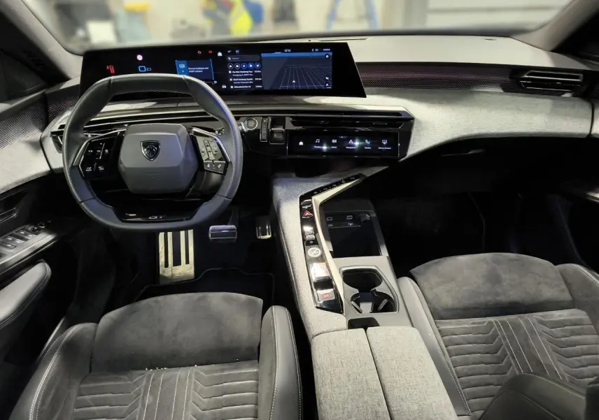 Intérieur Peugeot 3008 Hybrid 145 GT vu de face, sellerie Alcantara gris et tableau de bord numérique panoramique.