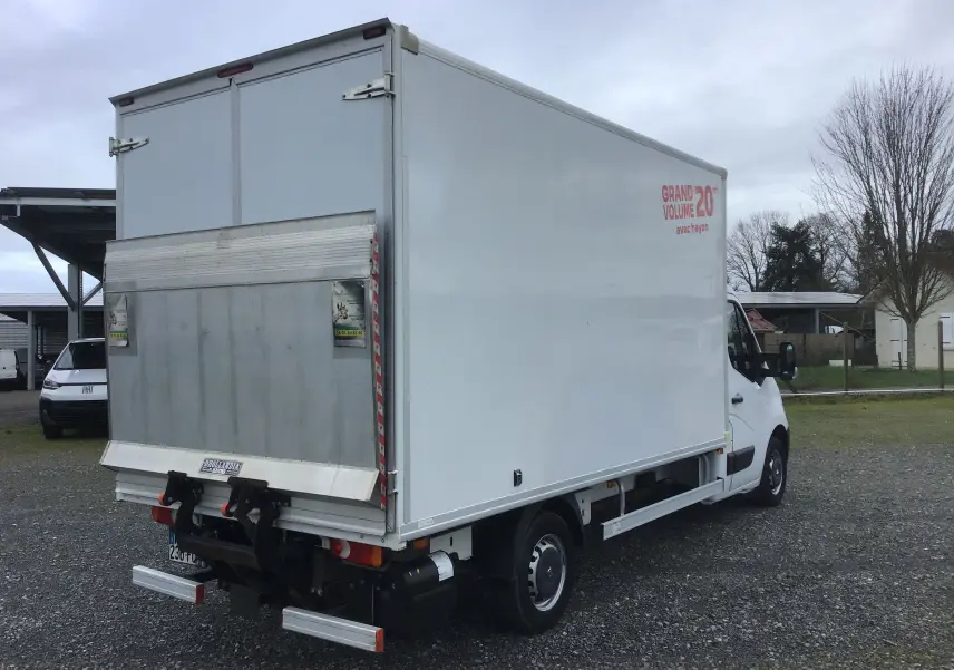 Vue 3/4 arrière droite d’un utilitaire blanc Opel Movano Châssis Cabine avec hayon élévateur et marquage "Grand Volume 20m3".