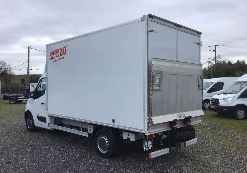 Vue 3/4 arrière droite d’un Opel Movano blanc avec caisse 20m3 et hayon électrique sur parking extérieur.