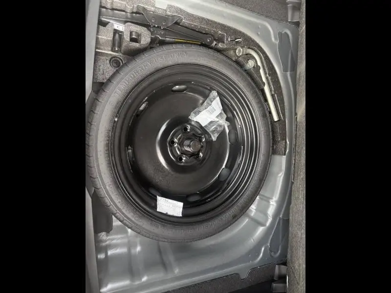 Gros plan sur la roue de secours noire dans le coffre du CUPRA Formentor 2025, entourée des outils de changement de pneu.