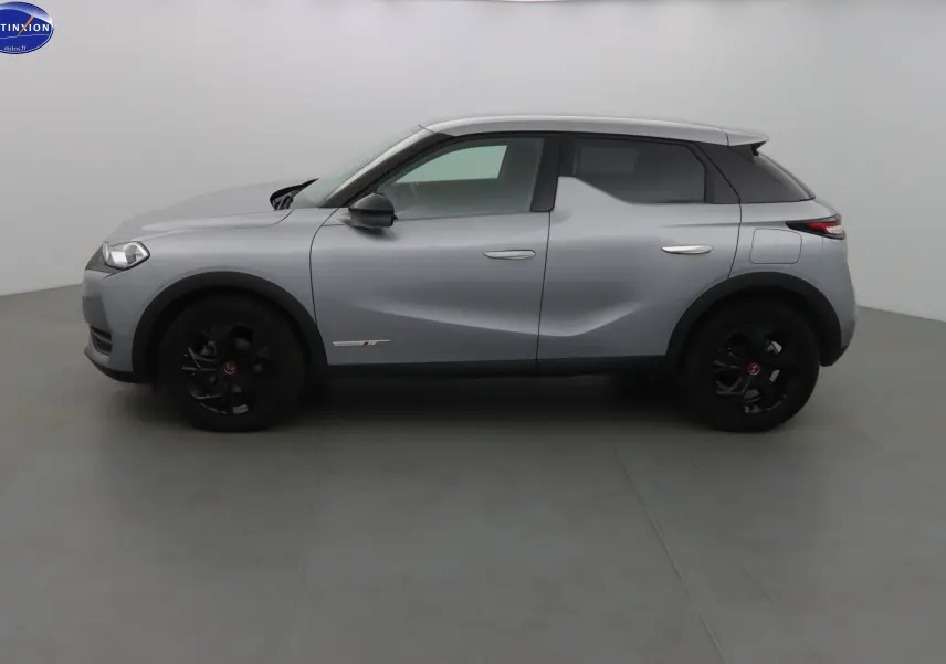 Profil côté gauche d'un DS3 Crossback gris Artense métal avec jantes noires et lignes sculptées visibles.