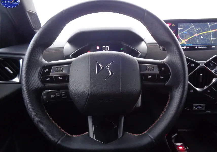 Volant en cuir noir avec logo DS au centre, tableau de bord numérique et écran tactile de navigation à droite.