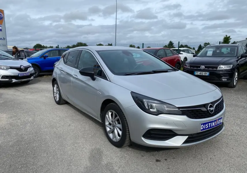 Opel Astra 2021 Sovereign Silver vue 3/4 avant droit avec jantes alliage 16'' gris argent et calandre noire.