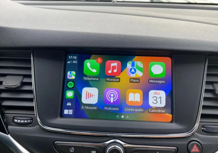 Écran tactile multimédia 7 pouces de l'Opel Astra 2021 affichant Apple CarPlay avec plusieurs applications colorées.