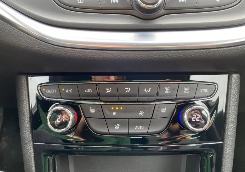 Panneau de commande de climatisation de l'Opel Astra 2021 avec réglages digitaux et boutons chauffants visibles.