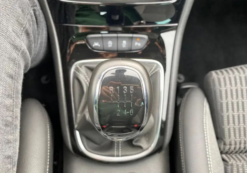 Le levier de vitesses manuel chromé de l'Opel Astra 2021, entouré de sellerie grise et console noire brillante.