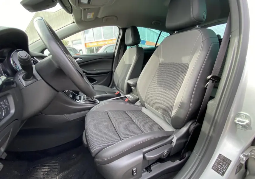 Intérieur de l'Opel Astra 2021 en Sovereign Silver, vue côté conducteur sur les sièges avant en tissu et cuir noir.