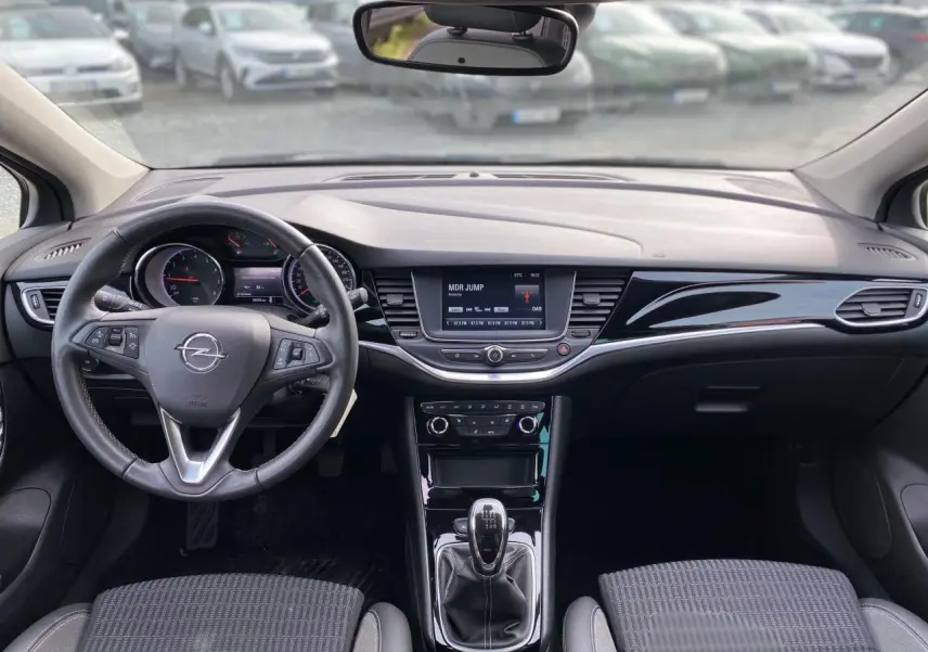 Intérieur de l'Opel Astra 2021 vu de face, tableau de bord noir avec écran tactile et volant multifonction.