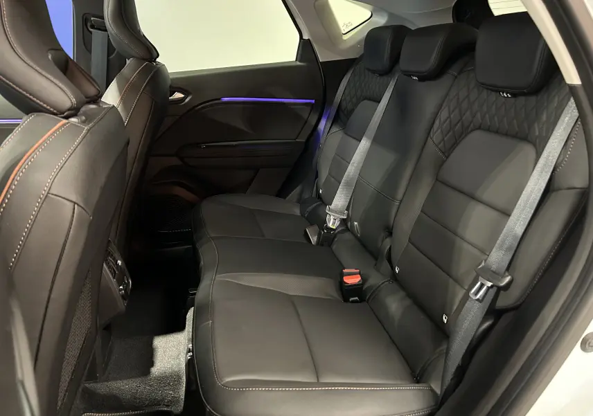 Vue côté droit de la banquette arrière en cuir noir avec surpiqûres orange du Renault Captur blanc nacré 2022.