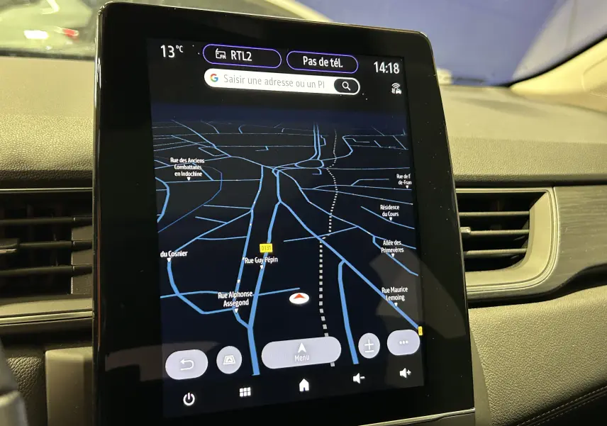 Écran tactile central du tableau de bord du Renault Captur blanc nacré, affichant la navigation GPS en mode nuit.