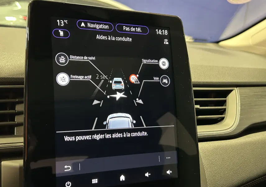 Écran tactile central du Renault Captur blanc nacré 2022 montrant les aides à la conduite activées.