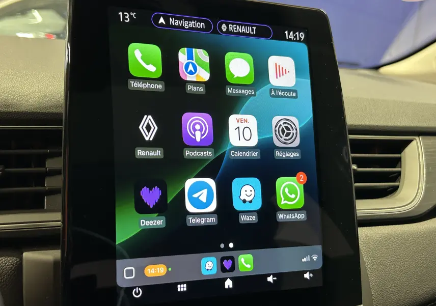 Écran tactile central du tableau de bord du Renault Captur blanc nacré, affichant les applications connectées.