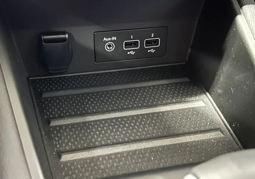 Gros plan sur la console centrale noire du Renault Captur II Iconic 2022 montrant les ports USB et prise Aux-In.