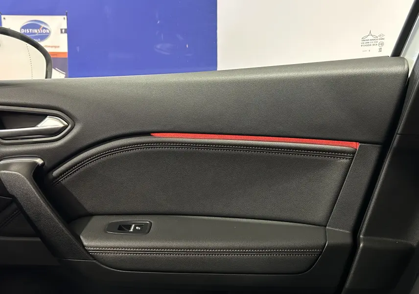 Intérieur côté gauche de la porte Renault Captur blanc nacré 2022 avec garniture noire et bande rouge décorative.