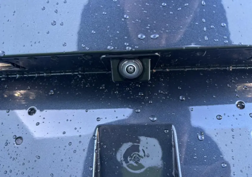 Gros plan sur la caméra de recul intégrée sur la malle arrière gris magnetic d'une SEAT LEON 2024.