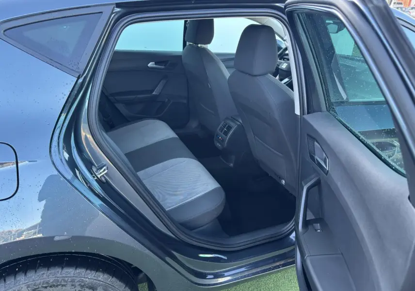 Vue intérieure arrière côté gauche d'une SEAT LEON gris magnetic 2024, montrant la banquette et les sièges avant.