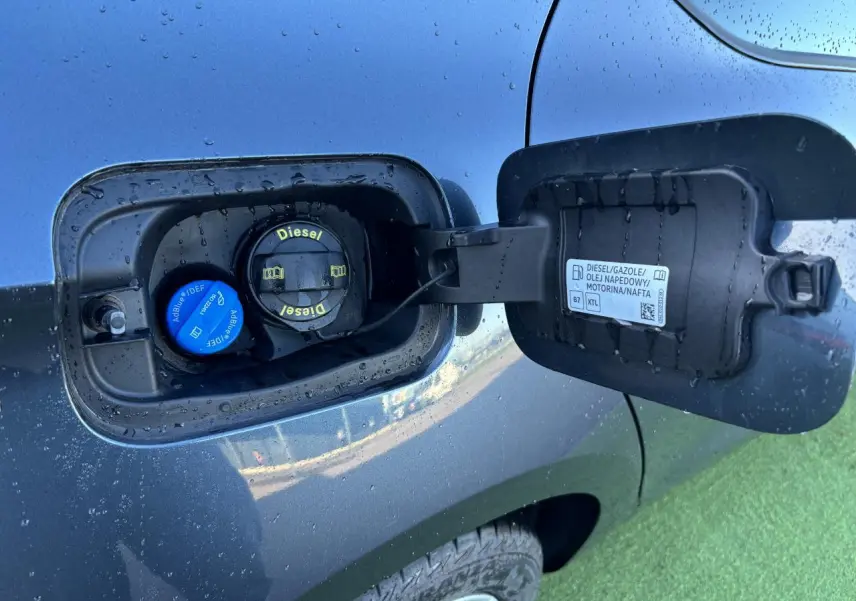 Gros plan sur la trappe à carburant côté gauche d'une SEAT LEON gris magnetic avec bouchons Diesel et AdBlue visibles.