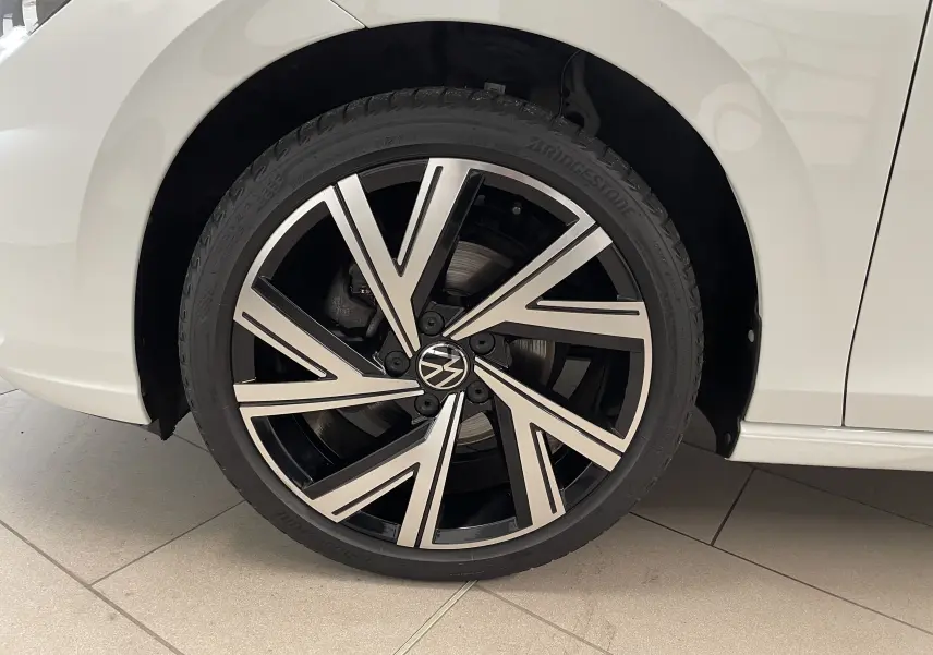 Gros plan sur la jante alliage Bergamo noire et argent d'une Volkswagen Golf blanche côté arrière droit.