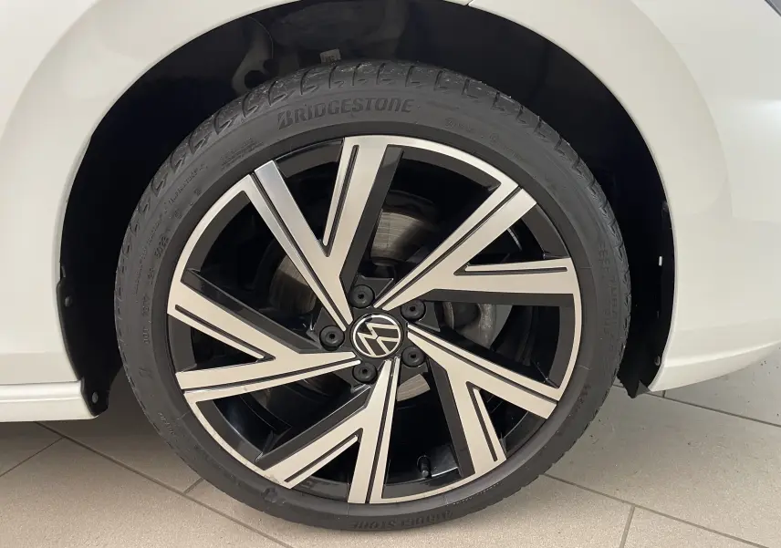 Gros plan sur la jante alliage Bergamo noire et argentée de la Volkswagen Golf blanche côté arrière droit.