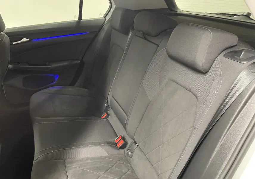 Banquette arrière en tissu gris avec surpiqûres, vue côté gauche d'une Volkswagen Golf blanche 2023.