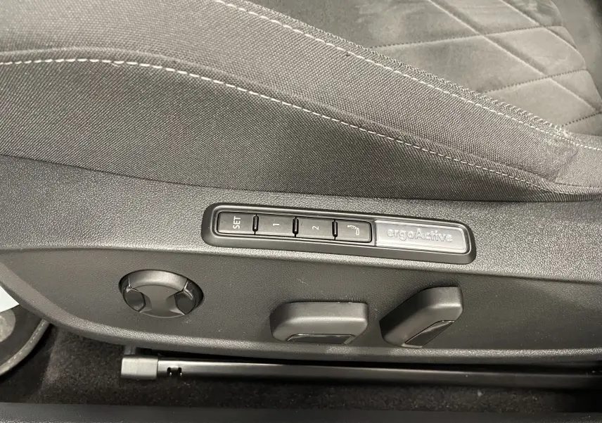 Gros plan sur les commandes de réglage électrique du siège conducteur de la Volkswagen Golf 1.5 eTSI blanc pur 2023.