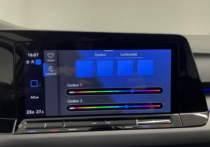 Écran tactile intérieur de la Volkswagen Golf 1.5 eTSI 2023 montrant les réglages de couleur et luminosité de l'ambiance lumineuse.