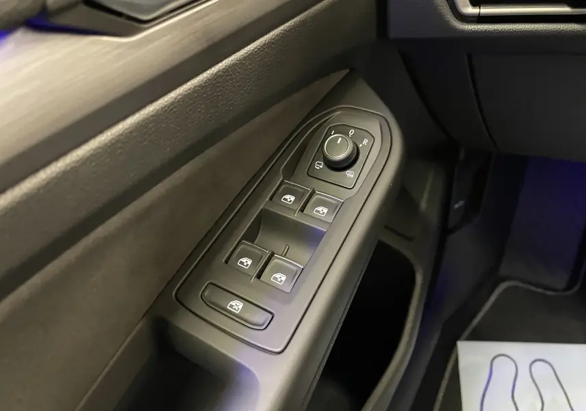 Commande des vitres et réglage des rétroviseurs sur la porte côté conducteur d'une Volkswagen Golf blanche 2023.