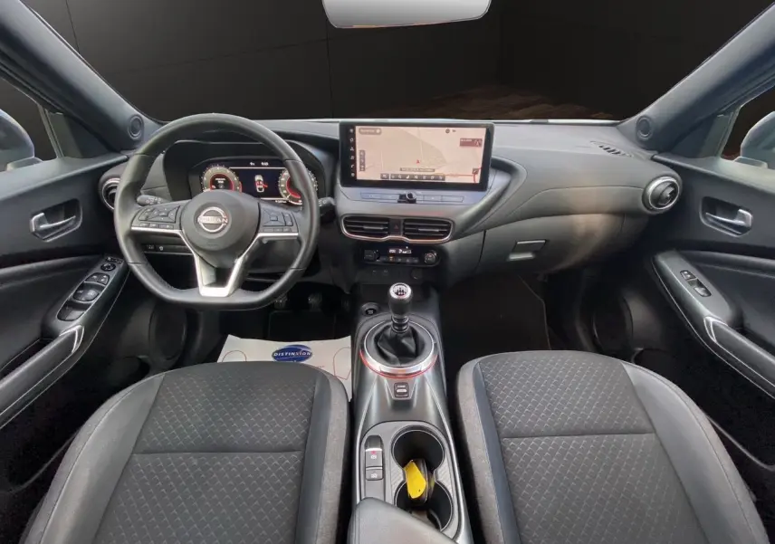 Intérieur noir du Nissan Juke 2025 vu de face, avec tableau de bord digital et écran tactile central.