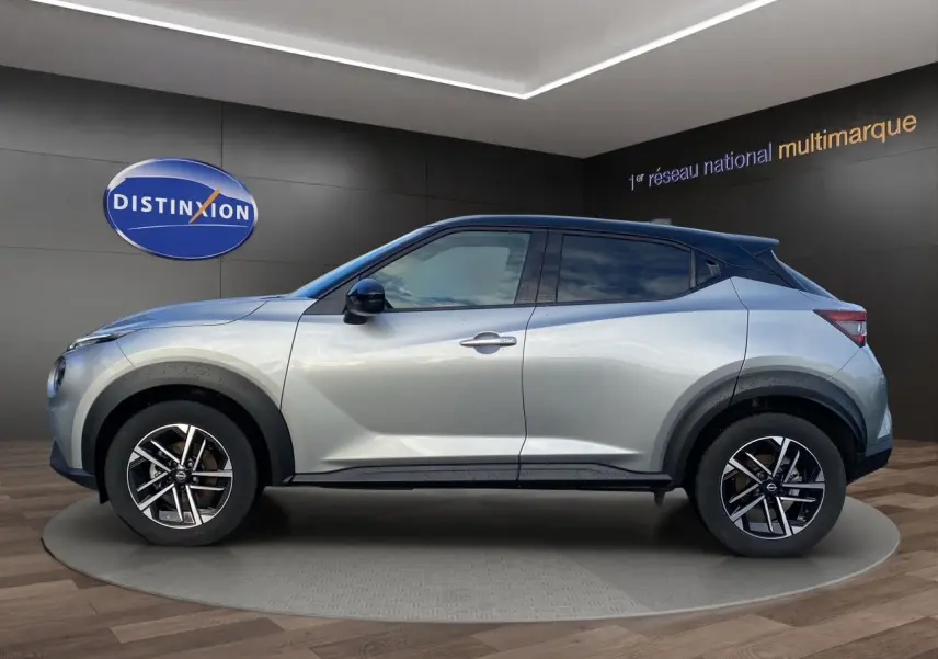 Vue de profil côté gauche d'un Nissan Juke 2025 gris perle avec toit noir et jantes alliage 17 pouces.