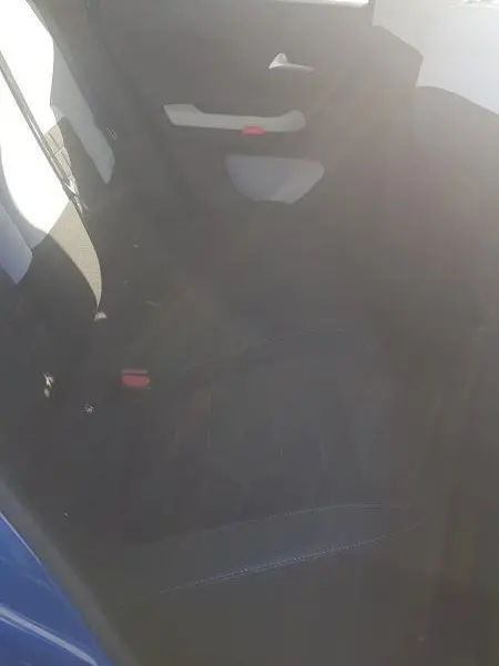 Vue intérieure arrière côté gauche de la Citroën C3 bleu foncé, montrant la banquette et la portière avec poignée blanche.