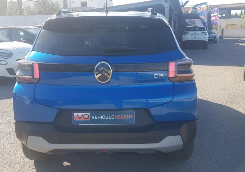 Vue arrière d'une Citroën C3 bleu foncé 2024 avec barres de toit et jantes alliage 17 pouces.