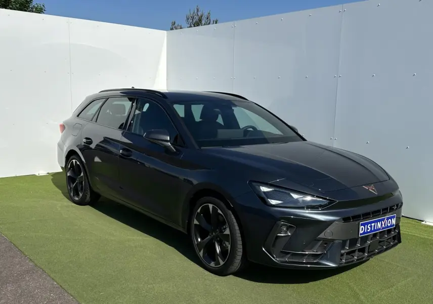 Vue 3/4 avant droite d'une CUPRA Leon Sportstourer 2025 en gris magnétique avec jantes alliage noires et signature lumineuse Tri-LED.