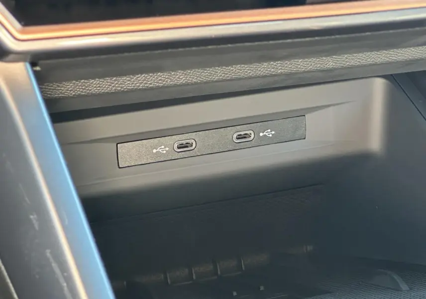 Gros plan sur deux prises USB-C éclairées dans la console centrale d'une CUPRA Leon Sportstourer gris magnétique 2025.